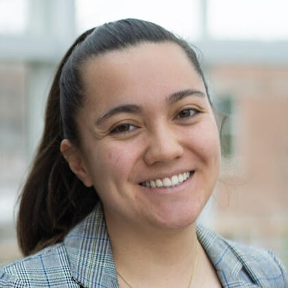 Lily Benig Headshot headshot of woman with brown eyes and brown hair in ponytail smiling